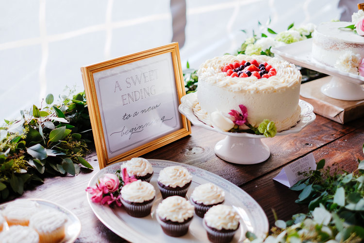 Plate of cupcakes next to an elegant cake