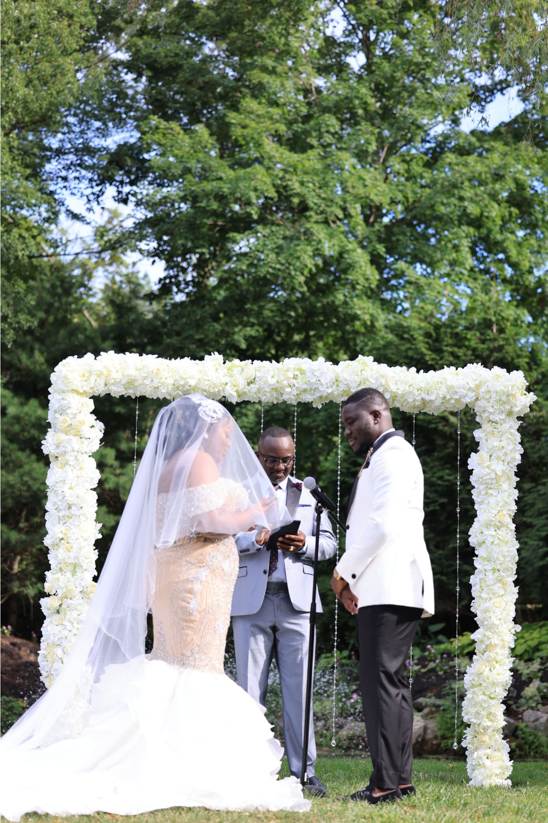 A groom and bride standing near reception gate.
