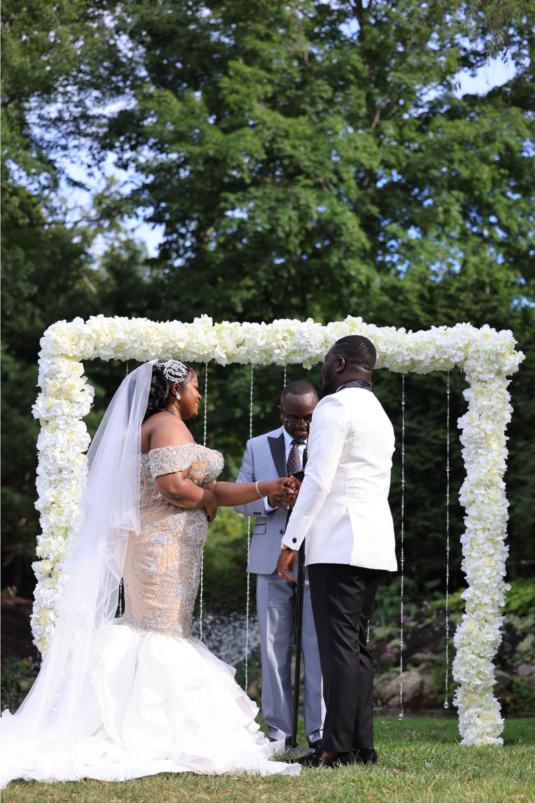 A Bride and groom standing with reception gate with photographer.